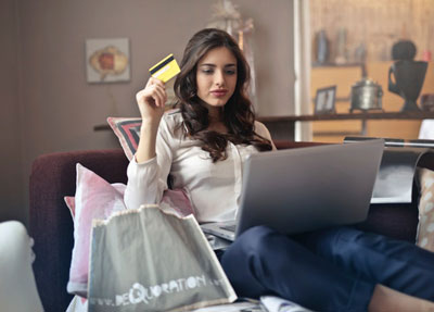 Woman holding credit card shopping online on her laptop